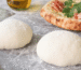 masa de pizza artesanal hecha a mano sobre mesa enharinada